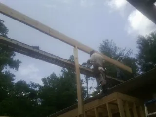 Carpenter setting a ridge beam over a new addition frame — Ice Dam Removal by Roofing Brothers in Hayesville